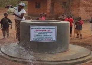Community member using a bucket water well in rural Malawi